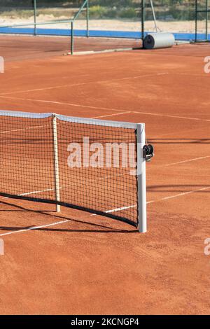 Baseline e al netto di un campo da tennis in terra battuta in una giornata di sole Foto Stock