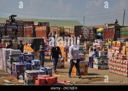 I lavoratori di Kashmiri trasportano scatole di mele da caricare su camion in un mercato all'ingrosso di frutta a Sopore, distretto di baramulla, Jammu e Kashmir, India, circa 54kms km a nord di Srinagar, il 28 settembre 2021. Jammu & Kashmir vanta di circa il 80% di quota di mela totale prodotta nel country.Â la coltivazione di mele e la sua catena di valore è uno dei principali soggiorni dell'economia rurale con un reddito di circa RS. 1500 crores.Â la produzione di mele è prevalentemente limitata ai distretti di Srinagar, Ganderbal, Budgam, Baramulla, Kupwara, Anantnag e Shopian nella provincia del Kashmir. (Foto di Nasir Kachroo/NurPhoto) Foto Stock