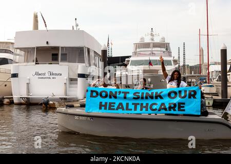 I Virginiani occidentali protestano contro la casa galleggiante del senatore Joe Manchin, quasi il cielo, nella marina di Washington. I dimostranti lo stanno esortando ad approvare il Build Back Better Act (noto anche come budget per la riconciliazione) e i suoi investimenti in soluzioni per l'assistenza sanitaria, la cittadinanza e il clima. (Foto di Allison Bailey/NurPhoto) Foto Stock