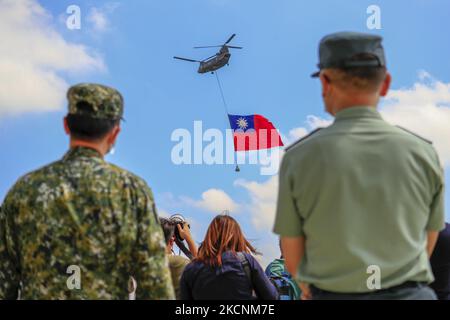 I soldati taiwanesi stanno a guardia mentre un elicottero Chinook che trasporta una tremenda bandiera di Taiwan vola su un campo militare, come parte di una prova per la performance flyby per la celebrazione della Giornata Nazionale della doppia decina di Taiwan, tra le crescenti tensioni tra Pechino e Taipei e le minacce provenienti dalla Cina, a Taoyuan, Taiwan 28 settembre 2021. La bandiera taiwanese larga 18 metri e lunga 12 metri, secondo la state media Central News Agency, sarà portata da due elicotteri CH-47 Chinook battenti bandiera sopra l'edificio presidenziale il 10 ottobre, mentre l'isola sta sviluppando legami migliori con gli Stati Uniti, il Regno Unito, l'Austr Foto Stock