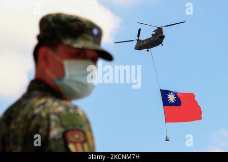 I soldati taiwanesi stanno a guardia mentre un elicottero Chinook che trasporta una tremenda bandiera di Taiwan vola su un campo militare, come parte di una prova per la performance flyby per la celebrazione della Giornata Nazionale della doppia decina di Taiwan, tra le crescenti tensioni tra Pechino e Taipei e le minacce provenienti dalla Cina, a Taoyuan, Taiwan 28 settembre 2021. La bandiera taiwanese larga 18 metri e lunga 12 metri, secondo la state media Central News Agency, sarà portata da due elicotteri CH-47 Chinook battenti bandiera sopra l'edificio presidenziale il 10 ottobre, mentre l'isola sta sviluppando legami migliori con gli Stati Uniti, il Regno Unito, l'Austr Foto Stock