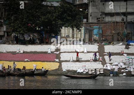 I lavoratori hanno sparso trucioli di plastica riciclata dopo il lavaggio nel fiume Buriganga a Dhaka, Bangladesh il 29 settembre 2021. Il fiume Buriganga, che scorre dalla città di Dhaka, è oggi uno dei fiumi più inquinati del mondo a causa del dilagante dumping di sprechi umani e industriali. (Foto di Syed Mahamudur Rahman/NurPhoto) Foto Stock