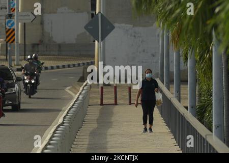 Una donna che indossa una maschera facciale cammina vicino al ponte Krung Thep a Bangkok il 1 ottobre 2021 a Bangkok, Thailandia. (Foto di Vachira Vachira/NurPhoto) Foto Stock