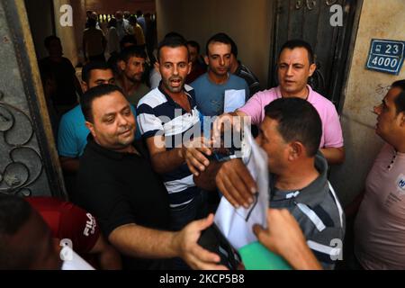 Gli uomini palestinesi si riuniscono per richiedere permessi di lavoro in Israele, nel campo profughi di Jabalia nella striscia di Gaza settentrionale, il 6 ottobre 2021. (Foto di Majdi Fathi/NurPhoto) Foto Stock