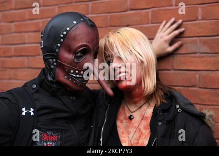 Crazy coppia danzante e indossando dinosauro t-rex e maschera unicorno -  Senior elegante persone aventi una divertente mascherata alla sfilata di  carnevale Foto stock - Alamy