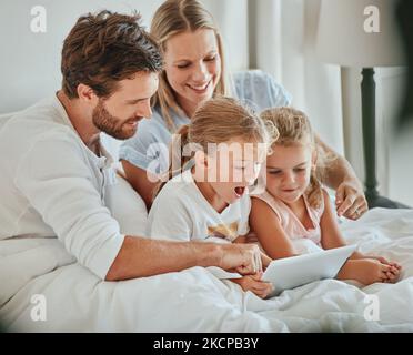 Genitori, bambini e tablet imparano in camera da letto, giochi e guardando cartoni animati su Internet, online e rilassarsi a casa. Famiglia felice di mamma, papà ed eccitato Foto Stock