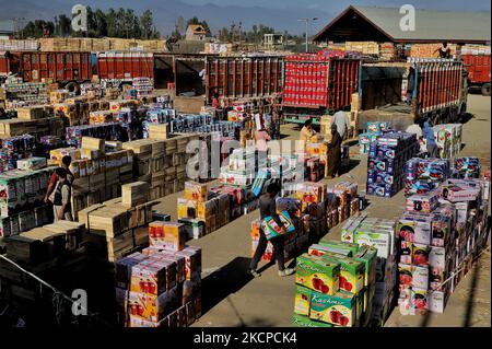 I Labourers trasportano le scatole delle mele da caricare sui camion ad un mercato all'ingrosso della frutta a Sopore, distretto baramulla, Jammu e Kashmir, India, circa 54kms a nord di Srinagar, il 10 ottobre 2021. Fruit Mandi sopore è il 2nd più grande mercato di Apple in Asia. Le mele Kashmiri forniscono un sostentamento a circa 3,5 milioni di persone, contribuendo al contempo a circa 8.000 dollari di reddito croro nella regione. Il Kashmir produce circa due milioni di tonnellate di mele e quasi due terzi di esse va ai mercati non locali. (Foto di Nasir Kachroo/NurPhoto) Foto Stock