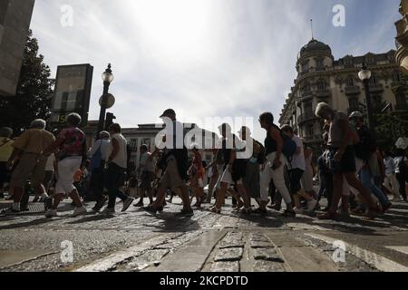 Le persone con e senza maschere facciali a causa della pandemia di coronavirus attraversano un crosswalk durante il Pilar e la Giornata Nazionale lungo fine settimana a Granada, Spagna il 11 ottobre 2021. La gente del posto apprezza il bel tempo mangiando o camminando per le strade di Granada, come molti turisti vengono a visitare la città durante questi festeggiamenti. (Foto di Ãlex CÃ¡mara/NurPhoto) Foto Stock