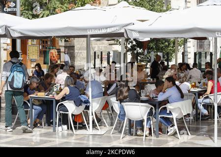 Persone sulla terrazza di un bar durante il Pilar e la Giornata Nazionale lungo fine settimana a Granada, Spagna il 11 ottobre 2021. La gente del posto apprezza il bel tempo mangiando o camminando per le strade di Granada, come molti turisti vengono a visitare la città durante questi festeggiamenti. (Foto di Ãlex CÃ¡mara/NurPhoto) Foto Stock