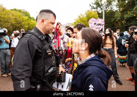 Gli attivisti nativi americani si trovano di fronte alla polizia del Parco degli Stati Uniti in un'azione di disobbedienza civile alla Casa Bianca contro l'uso continuato di combustibili fossili nella Giornata delle popolazioni indigene, il primo giorno di una settimana di azione ospitata da persone contro combustibili fossili. I manifestanti hanno due richieste importanti da parte dell’amministrazione Biden: Cessare l’approvazione dei progetti per le infrastrutture dei combustibili fossili e condurre una trasformazione dell’energia rinnovabile. (Foto di Allison Bailey/NurPhoto) Foto Stock