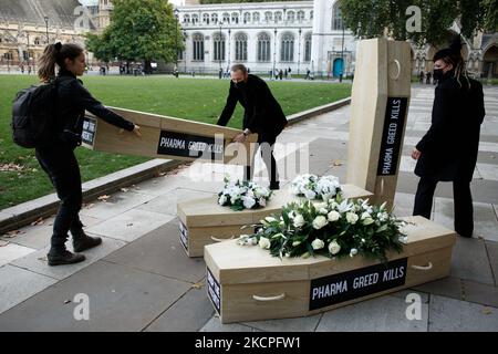 I membri del gruppo attivista Global Justice Adesso che si battono per le aziende farmaceutiche per sospendere i brevetti sui vaccini covid-19 organizzano bare finte in vista di una "marcia funeraria" da Parliament Square a Downing Street a Londra, Inghilterra, il 12 ottobre 2021. La giustizia globale ora ha citato il Regno Unito per le critiche per essersi opposto alle proposte di sospensione dei brevetti del 19 presso l’Organizzazione mondiale del commercio. La sospensione dei brevetti contenderebbe "permettere al mondo di accelerare la produzione” di vaccini covid-19 e di evitare uno stato di "apartheid vaccino” che si sviluppa tra paesi ricchi e poveri. (Foto di DAV Foto Stock