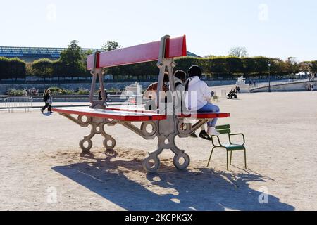 Tre ragazze sedute sulla doppia panchina, un lavoro di Lilian Bourgeat nel giardino delle Tuileries per la FIAC 2021.(Foto di Vincent Koebel/NurPhoto) Foto Stock