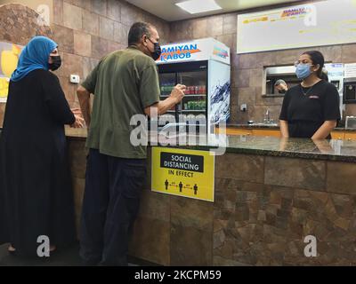 I patroni ordinano il cibo in un ristorante durante la pandemia del nuovo coronavirus (COVID-19) a Toronto, Ontario, Canada il 14 ottobre 2021. Tutti i residenti dell'Ontario che hanno almeno 12 anni sono già tenuti a mostrare una prova di vaccinazione (sotto forma di certificati di vaccino COVID-19) per cenare in ristoranti, nonché visitare palestre, cinema e altri ambienti interni ad alto rischio, tra cui luoghi per eventi sportivi e concerti. I membri del pubblico sono attualmente tenuti a mostrare una copia digitale o cartacea della loro ricevuta del vaccino COVID-19 per dimostrare che sono stati vaccinati completamente, con un vaccino con codice QR migliorato Foto Stock