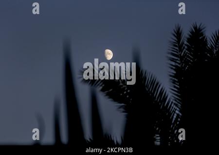 La luna sorge sulla città di Deir al-Balah nella striscia centrale di Gaza, venerdì 15 ottobre 2021. (Foto di Sameh Rahmi/NurPhoto) Foto Stock