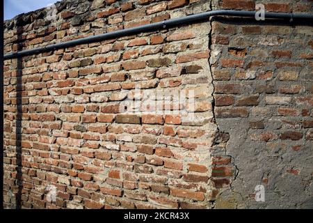 Angolo di un muro di mattoni con tubazioni su di esso Foto Stock