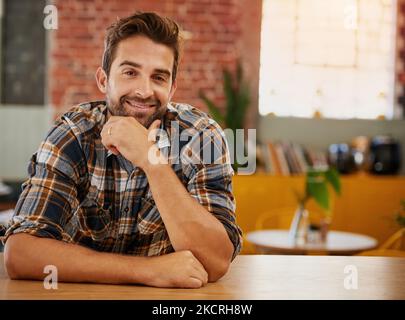 Il lavoro autonomo sembra buono su di voi. Ritratto di un giovane imprenditore fiducioso in posa al bancone nel suo bar. Foto Stock