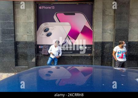 Le persone sono viste di fronte a un iPhone 13 pubblicità , al di fuori di un negozio a Kolkata , India , il 29 ottobre 2021 . Il CEO di Apple ha annunciato che l'azienda ha guadagnato il 29% nelle vendite nello scorso trimestre , a causa della stagione festiva in India . (Foto di Debarchan Chatterjee/NurPhoto) Foto Stock