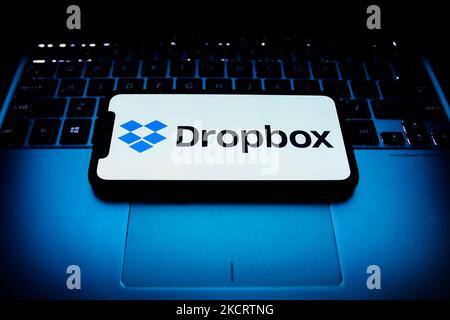 Il logo Dropbox visualizzato sullo schermo del telefono e la tastiera di un computer portatile sono visibili in questa foto di illustrazione scattata a Cracovia il 30 ottobre 2021. (Foto di Jakub Porzycki/NurPhoto) Foto Stock