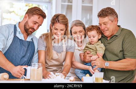 Nonni, genitori e capretto cottura, felice ed amare insieme in cucina. Famiglia, cucina e sorriso con felicità, trascorrere tempo di qualità e. Foto Stock