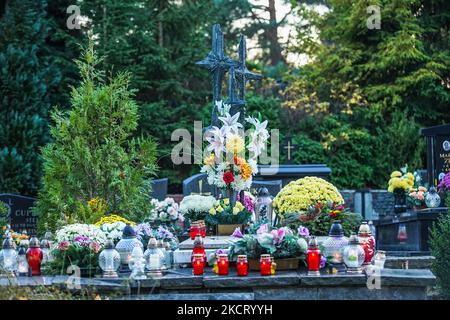 Le persone che visitano le tombe dei loro parenti al cimitero di Lostowicki sono viste a Danzica, Polonia il 31 ottobre 2021 il popolo cristiano celebra la Giornata dei Santi (Wszystkich Swietych), rispetta i membri della famiglia morti, depongono fiori e candele accese sulle tombe. La Giornata dei Santi il 1 novembre e la Giornata delle ANIME il 2 novembre sono le festività in cui milioni di polacchi visitano le tombe dei propri cari, spesso percorrendo centinaia di chilometri fino alle loro città d'origine. Nel 2021 come il 1st novembre è il Lunedi molte persone visitano tombe nel fine settimana che precede quel giorno. (Foto di Michal Fludra/NurPhoto) Foto Stock