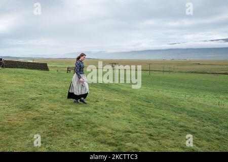 Guida femminile in abito tradizionale a Glaumbaer durante l'estate nel nord dell'Islanda Foto Stock