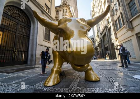 La gente posa accanto alla statua 'Charging Bull' (conosciuta come Bull Wall Street) replica di fronte alla Borsa di San Paolo (B3) sede, a San Paolo, Brasile, il 18 novembre 2021 (Foto di Cris FAGA/NurPhoto) Foto Stock