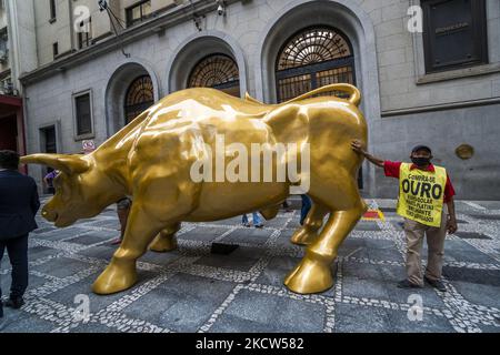 La gente posa accanto alla statua 'Charging Bull' (conosciuta come Bull Wall Street) replica di fronte alla Borsa di San Paolo (B3) sede, a San Paolo, Brasile, il 18 novembre 2021 (Foto di Cris FAGA/NurPhoto) Foto Stock