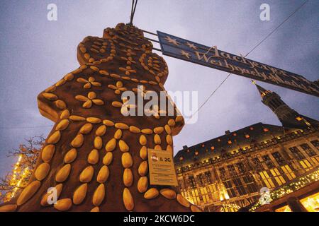 Printenmann, uomo di pan di zenzero, è visto con 2G segno di regola è visto di fronte al Municipio di Aachen, Germania il 19 novembre 2021 durante il giorno di apertura del mercato di Natale come regola 2G si applica come i visitatori richiedono la vaccinazione completa o recuperato (Foto di Ying Tang/NurPhoto) Foto Stock