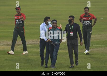 Un funzionario della sicurezza rimuove un sostenitore del Bangladesh dal campo di cricket durante la seconda partita internazionale di cricket del Twenty20 tra Bangladesh e Pakistan allo Sher-e-Bangla National Cricket Stadium di Dhaka il 20 novembre 2021. (Foto di Ahmed Salahuddin/NurPhoto) Foto Stock