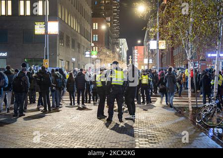 Protesta contro le misure del Covid-19 all'Aia di fronte alla stazione ferroviaria centrale di Den Haag nel centro della città e sul canale, dopo la conferenza stampa con una maggiore presenza della polizia con le unità di polizia antisommossa, i veicoli che circondano la protesta, le telecamere di sorveglianza e altro ancora. Il primo ministro Mark Rutte annuncia nuove misure anti-Corona in una conferenza stampa dopo che il governo ha avuto una riunione. Le nuove misure per combattere la diffusione della pandemia di Covid includono la chiusura di bar, ristoranti e negozi non essenziali a 5pm. Gli ospedali olandesi hanno avvertito della situazione critica con il codice nero. La rete Foto Stock