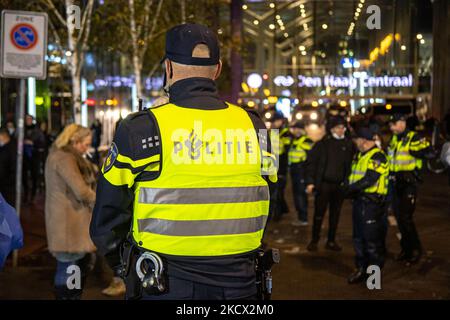 Protesta contro le misure del Covid-19 all'Aia di fronte alla stazione ferroviaria centrale di Den Haag nel centro della città e sul canale, dopo la conferenza stampa con una maggiore presenza della polizia con le unità di polizia antisommossa, i veicoli che circondano la protesta, le telecamere di sorveglianza e altro ancora. Il primo ministro Mark Rutte annuncia nuove misure anti-Corona in una conferenza stampa dopo che il governo ha avuto una riunione. Le nuove misure per combattere la diffusione della pandemia di Covid includono la chiusura di bar, ristoranti e negozi non essenziali a 5pm. Gli ospedali olandesi hanno avvertito della situazione critica con il codice nero. La rete Foto Stock
