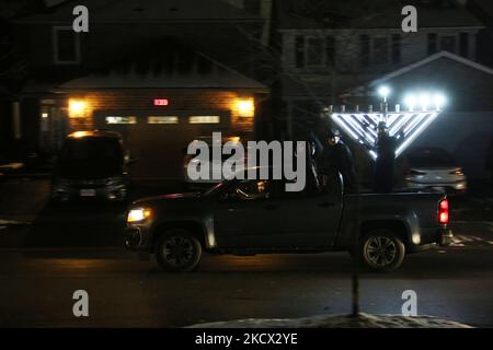 Ebrei assidici del Chabad Lubavitch guidano veicoli con grandi menorah attaccati ai tetti delle loro auto e pick-up camion con menorah giganti durante una grande Car Menorah Parade la terza notte della festa ebraica di Hanukkah (Chanukah) a Toronto, Ontario, Canada il 30 novembre 2021. Secondo Chabad Lubavitch ci sono stati affluenze record per Car Menorah parate in centinaia di città in tutto il mondo. L'anno scorso, circa 5.000 menorah auto-top hanno colpito strade in tutto il mondo. Quest'anno, si prevede che i numeri aumenteranno in modo esponenziale man mano che le sinagoghe e i centri della comunità capitalizzeranno o Foto Stock