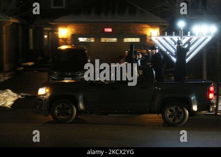 Ebrei assidici del Chabad Lubavitch guidano veicoli con grandi menorah attaccati ai tetti delle loro auto e pick-up camion con menorah giganti durante una grande Car Menorah Parade la terza notte della festa ebraica di Hanukkah (Chanukah) a Toronto, Ontario, Canada il 30 novembre 2021. Secondo Chabad Lubavitch ci sono stati affluenze record per Car Menorah parate in centinaia di città in tutto il mondo. L'anno scorso, circa 5.000 menorah auto-top hanno colpito strade in tutto il mondo. Quest'anno, si prevede che i numeri aumenteranno in modo esponenziale man mano che le sinagoghe e i centri della comunità capitalizzeranno o Foto Stock