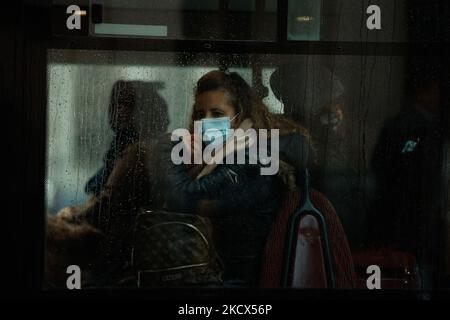 Una donna che indossa una maschera facciale viaggia su un autobus durante un pomeriggio di discesa a Londra, Inghilterra, il 1 dicembre 2021. Le maschere facciali sui trasporti pubblici sono state rese obbligatorie questa settimana di nuovo in tutta l'Inghilterra in seguito alla scoperta della variante di omicron del coronavirus covid-19. (Foto di David Cliff/NurPhoto) Foto Stock