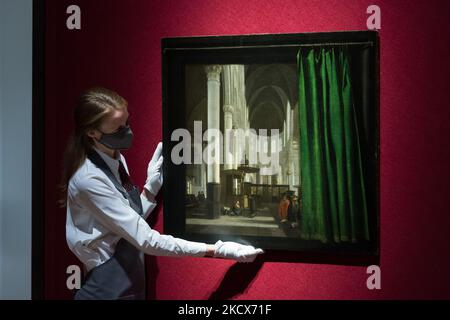 LONDRA, REGNO UNITO - 03 DICEMBRE 2021: Un membro dello staff detiene la "Interior of the Oude Kerk, Amsterdam" con una tenda e una cornice trompe l'oeil (1655) di Emmanuel de Witte (stima: 500.000-800.000 sterline), Che è stata ritirata agli eredi della Julius & Camilla Priester Collection dopo essere stata sequestrata con l'intera collezione dalle autorità naziste di Vienna tra il 1938 e il 1944, durante una telefonata fotografica che ha presentato gli highlighs della Classic Week alla casa d'aste di Christie il 03 dicembre 2021 a Londra, Inghilterra. (Foto di Wiktor Szymanowicz/NurPhoto) Foto Stock