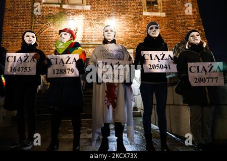 Le persone che indossano maschere tenere striscioni lettura 'gravidanza' con numero durante la partecipazione 'non voglio il mio sangue, Polonia!' Protesta alla piazza principale di Cracovia, Polonia, il 1st dicembre 2021. In tutto il paese si sono svolte manifestazioni per protestare contro un piano governativo per registrare ogni gravidanza in una banca dati nazionale e mentre il parlamento si prepara a discutere una nuova proposta per limitare ulteriormente l'aborto. (Foto di Beata Zawrzel/NurPhoto) Foto Stock