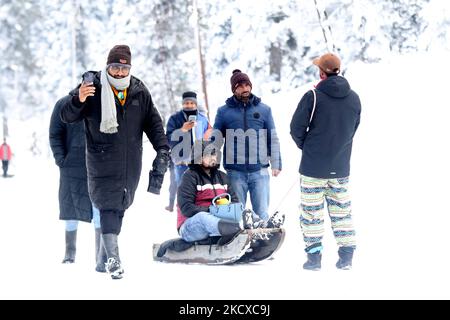 I turisti che si godono un giro in slitta presso il famoso punto turistico dopo una fresca nevicata a Gulmarg, Jammu e Kashmir, India, il 06 dicembre 2021. Dopo una giornata di pioggia/neve, lunedì il tempo ha iniziato a migliorare a Jammu e Kashmir e Ladakh. (Foto di Nasir Kachroo/NurPhoto) Foto Stock