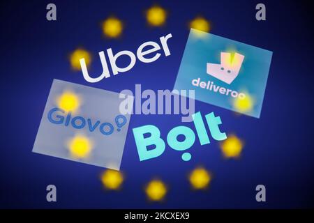 I logo Uber, Deliveroo, Glovo e Bolt visualizzati sullo schermo del telefono sono visualizzati con la bandiera dell'Unione europea visualizzata su uno schermo in questa foto di illustrazione a esposizione multipla scattata a Cracovia, Polonia il 7 dicembre 2021. (Foto di Jakub Porzycki/NurPhoto) Foto Stock