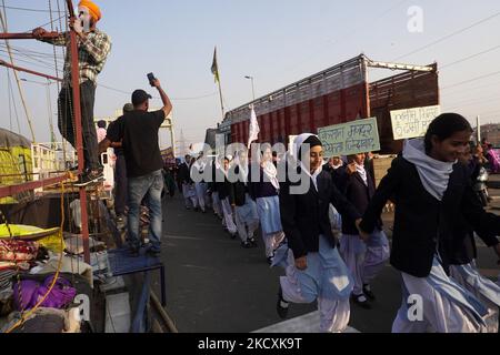 Gli studenti della scuola intraprendono una marcia di vittoria mentre gli agricoltori si preparano a lasciare il sito di protesta, dopo che il governo ha accettato per quanto riguarda la gamma di questioni, tra cui la garanzia sul prezzo minimo di sostegno (MSP), al confine di Ghazipur alla periferia di Nuova Delhi, India il 11 dicembre 2021. (Foto di Mayank Makhija/NurPhoto) Foto Stock