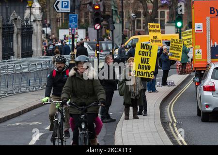 LONDRA, REGNO UNITO - 13 DICEMBRE 2021: I dimostranti protestano al di fuori delle Camere del Parlamento contro i passaporti e i mandati dei vaccini mentre l'implementazione dei vaccini di richiamo è estesa a tutti gli adulti in Inghilterra questa settimana per contribuire ad affrontare l'aumento dei casi di coronavirus di Omicron il 13 dicembre 2021 a Londra, Inghilterra. Ieri, il primo ministro britannico Boris Johnson ha annunciato il piano del governo di erogare colpi di richiamo a tutti gli adulti entro il nuovo anno, per un valore medio di 1 milioni di dosi al giorno, Dato che il Covid Alert del Regno Unito è stato portato al livello 4 a causa del rapido aumento dei casi di Omicron. (P Foto Stock