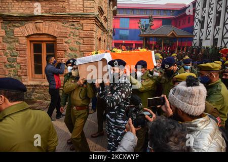 Le forze di polizia indiane trasportano il corpo morto del poliziotto Rameez Ahmad a Srinagar, indiano amministrato Kashmir il 14 dicembre 2021. Tre poliziotti sono stati uccisi e altri 11 feriti dopo sospetti militanti hanno attaccato il loro autobus nella zona di Zewan, alla periferia di Srinagar. (Foto di Muzamil Mattoo/NurPhoto) Foto Stock