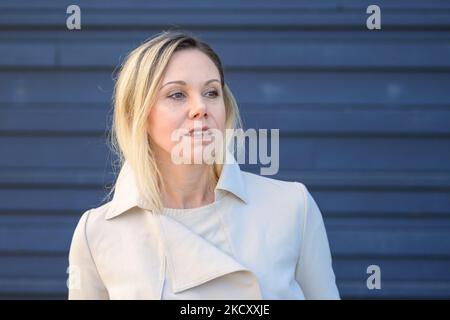 Ritratto di una bella donna bionda di mezza età che guarda pensieroso al lato di fronte a una parete blu Foto Stock