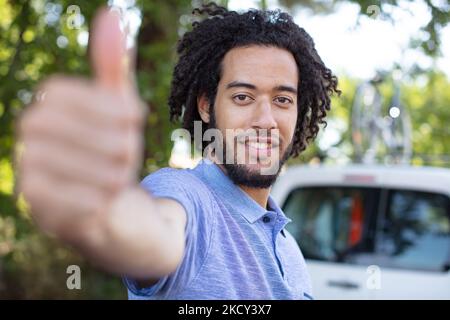 giovane uomo che mostra un simbolo di pollice in su Foto Stock