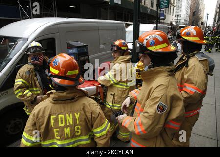 Il personale dei servizi medici di emergenza (EMS) è in attesa di ordini durante un incendio di un'auto al piano superiore di un garage di Midtown, il 24 dicembre 2021 a New York City USA. (Foto di John Lamparski/NurPhoto) Foto Stock