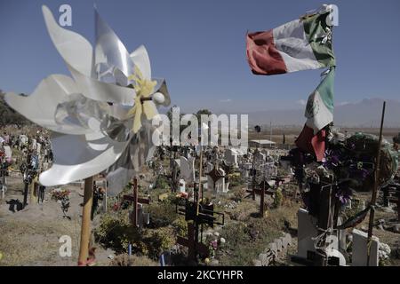 Una bandiera messicana vola all'interno del cimitero civile di Xico-Chalco nello Stato del Messico la vigilia di Capodanno durante l'emergenza sanitaria COVID-19 in Messico. In Messico, il 29 dicembre 2021. (Foto di Gerardo Vieyra/NurPhoto) Foto Stock