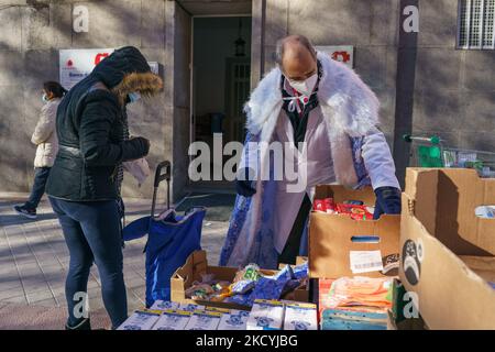 La gente raccoglie cibo e caramelle dalla Fundacion Madrina il 30 dicembre 2021 a Madrid, Spagna. La consegna di cibo e caramelle è rivolta ai bambini provenienti da famiglie vulnerabili. Gli eventi della Fondazione durante le vacanze natalizie hanno lo scopo di rendere omaggio ai bambini, considerando che hanno subito il dramma sociale delle loro famiglie a causa della situazione sanitaria. (Foto di Oscar Gonzalez/NurPhoto) Foto Stock