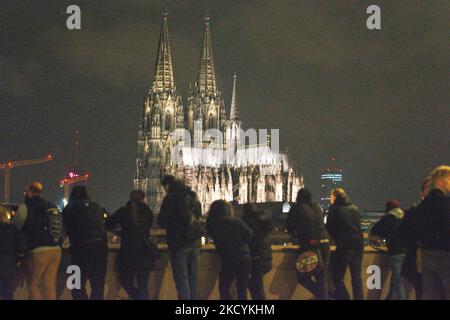 I visitatori sono visti dall'altra parte del fiume Reno di fronte alla Cattedrale di Dom a Colonia, in Germania, il 31 dicembre 2021, poiché la città ha istituito diverse zone senza fuochi d'artificio durante la vigilia di Capodanno per ridurre al minimo le persone socializzare alla vigilia di Capodanno (Foto di Ying Tang/NurPhoto) Foto Stock