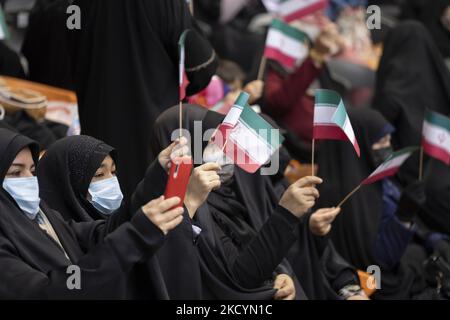 Le donne iraniane velate fanno sventolare le bandiere iraniane durante un anniversario di morte del comandante iraniano dell'IRGC, il generale Qasem Soleimani, ucciso in un attacco di droni USA a Baghdad, presso il complesso sportivo Azadi (Freedom) a Teheran occidentale il 1 gennaio 2022. Iran per celebrare il secondo anniversario di morte dell'ex comandante del corpo della Guardia rivoluzionaria Islamica (IRGC) Quds Force, Generale Qasem Soleimani, che ha ucciso in un attacco di droni USA all'aeroporto internazionale di Baghdad in Iraq. (Foto di Morteza Nikoubazl/NurPhoto) Foto Stock