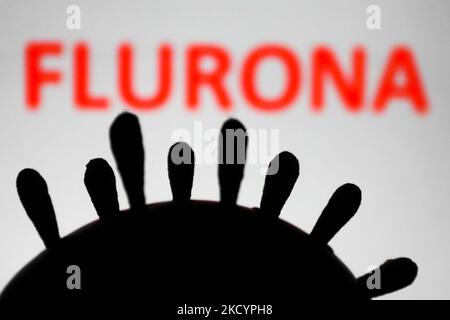 Il modello di coronavirus e il segno 'flurona' visualizzati sullo sfondo sono visti in questa foto di illustrazione scattata in Polonia il 4 gennaio 2022. Alcuni paesi hanno riportato casi di pazienti che erano stati infettati sia COVID-19 che influenza. (Foto di Jakub Porzycki/NurPhoto) Foto Stock
