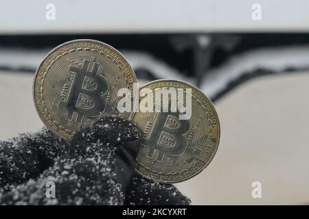 Immagine illustrativa di due bitcoins commemorativi visti di fronte all'auto Tesla durante il freddo venerdì 7 gennaio 2022 a Edmonton, Alberta, Canada. (Foto di Artur Widak/NurPhoto) Foto Stock